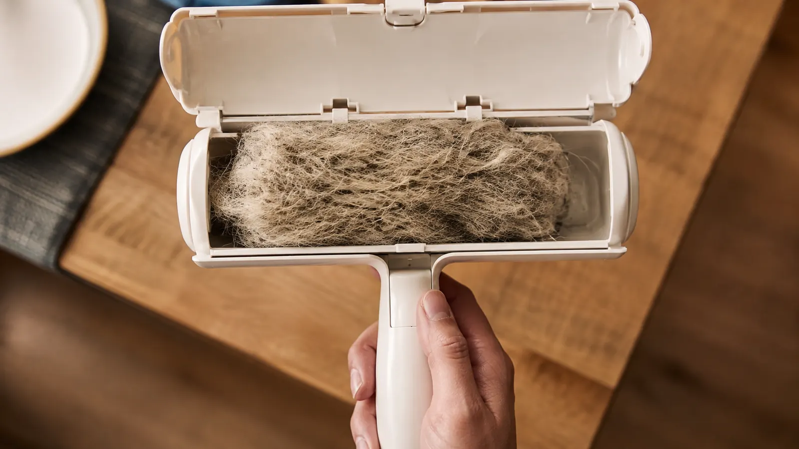 Inside of the opened roller tray showing a thick clump of gathered pet hair ready to empty